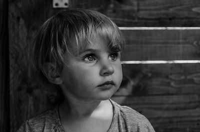 Close-up of cute girl looking away at home