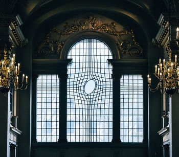 LOW ANGLE VIEW OF ORNATE GLASS WINDOW IN BUILDING