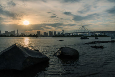 Bridge over sea against sky during sunset