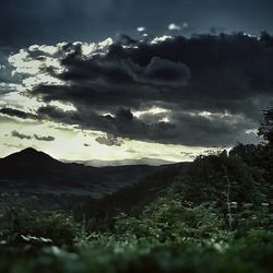 Scenic view of mountains against cloudy sky