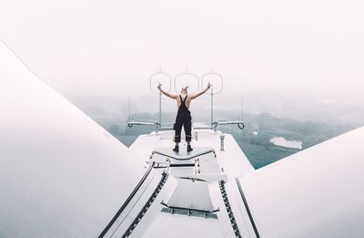 Rear view of man standing on wind turbine