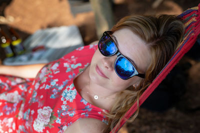 Outdoor portrait of woman relaxing in the hammock in the summer garden