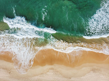 Aerial view of waves rushing towards beach