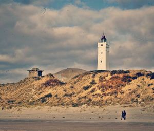 Lighthouse against cloudy sky