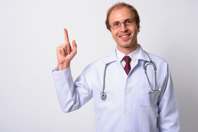 Portrait of smiling man standing against white background