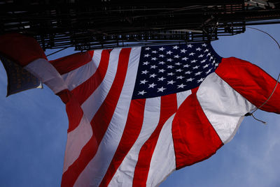 Low angle view of flags hanging against sky