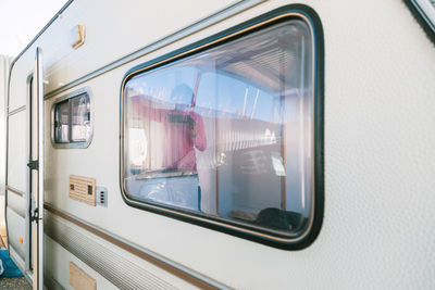 Woman seen through window of camper trailer