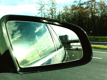 Reflection of clouds in side-view mirror