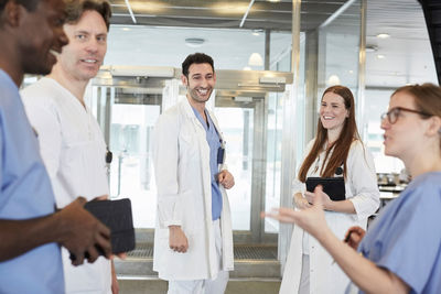 Smiling multi-ethnic healthcare team discussing at lobby in hospital