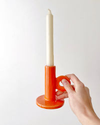 Close-up of hand holding against white background with a candlelight holder 