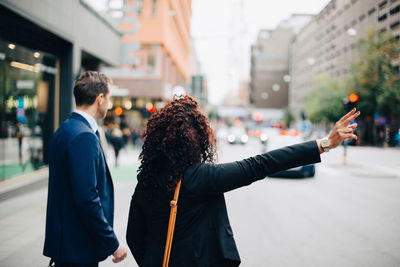 Rear view of people standing on street in city