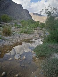 Scenic view of land and mountains against sky