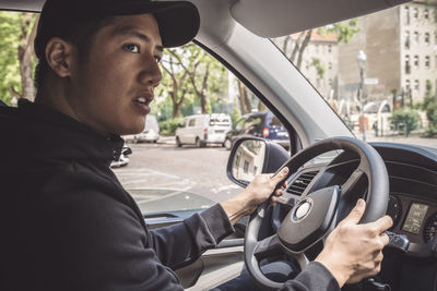 Side view of delivery man driving truck