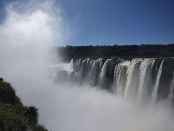 Scenic view of waterfall against sky