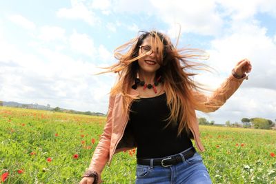 Portrait of young woman standing on field