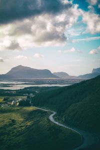 Scenic view of road by mountains against sky