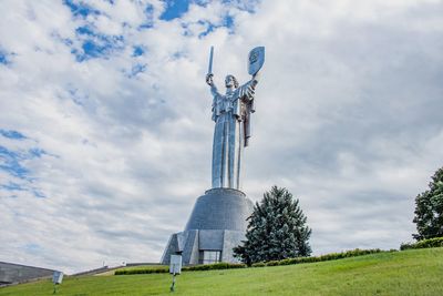 Statue on field against sky