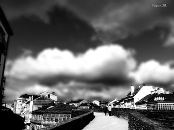 Buildings in city against cloudy sky