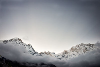 Low angle view of snowcapped mountains against clear sky