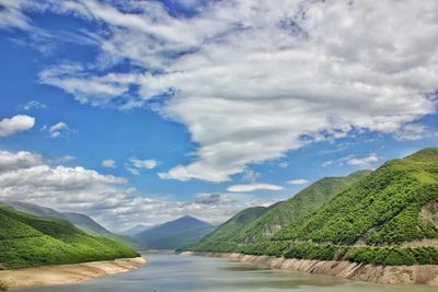 Scenic view of river amidst mountains against sky