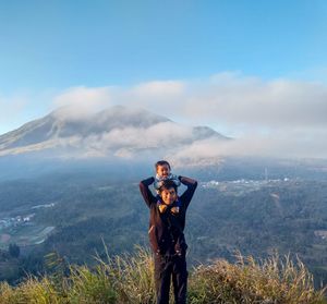 Full length of man standing on mountain against sky