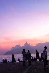 Silhouette people at beach against sky during sunset in rio de janeiro