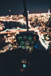 Illuminated city seen from helicopter cockpit at night