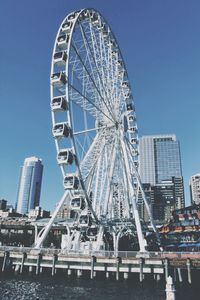 Low angle view of ferris wheel against blue sky