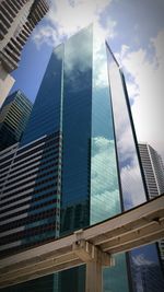 Low angle view of modern building against cloudy sky