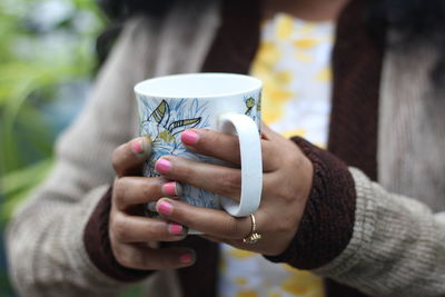 Close-up of hand holding coffee cup