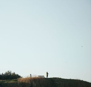 Man standing on field against clear sky