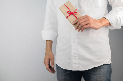 Midsection of man standing against white background