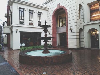 Fountain by building in city