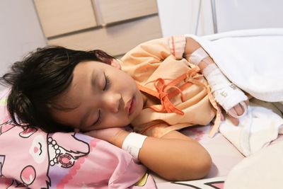 Cute baby girl sleeping on bed in hospital
