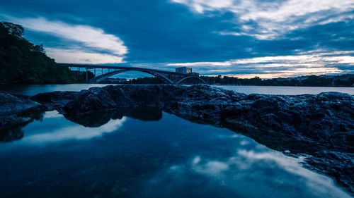 Arch bridge over river against sky