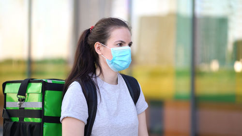 Young woman wearing mask standing outdoors