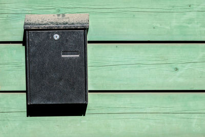 Close-up of closed mailbox on wooden floor