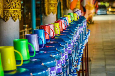 Close-up of multi colored cups in row