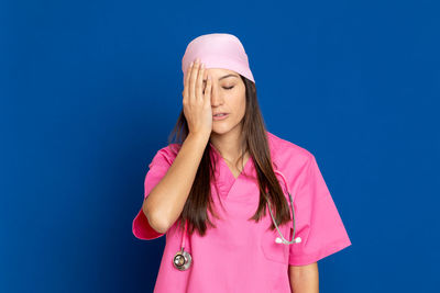 Portrait of woman standing against pink blue sky