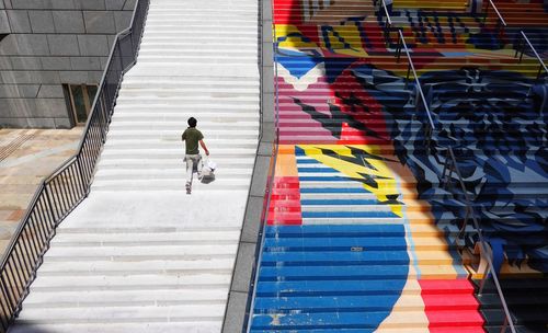 Rear view of man walking on staircase