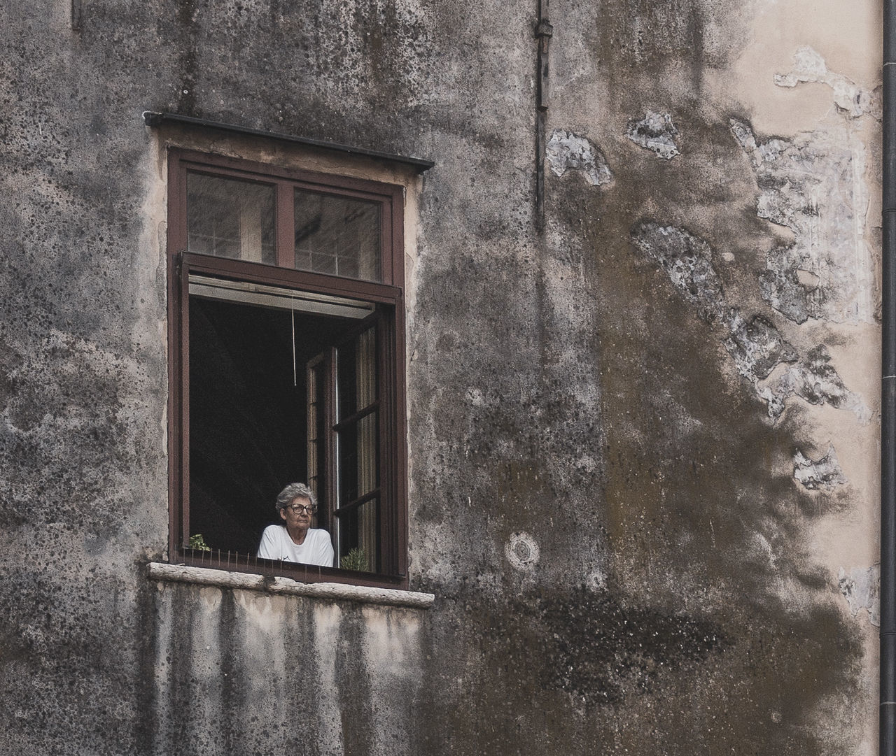 PORTRAIT OF MAN IN FRONT OF WINDOW OF BUILDING