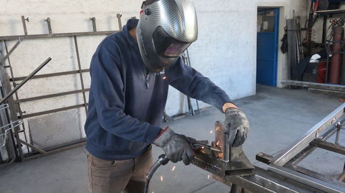 Worker welding metal at factory