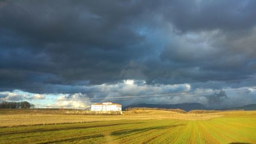 Scenic view of field against cloudy sky