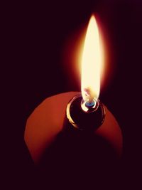 Close-up of lit candle in dark room