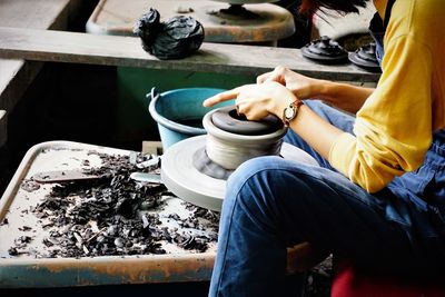 Midsection of man sitting in kitchen