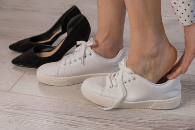 Low section of woman standing on hardwood floor