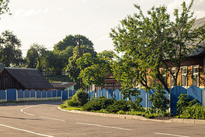 Houses by trees against sky in city