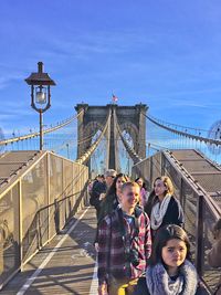 People on bridge against sky