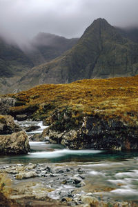 Scenic view of river and mountains against sky