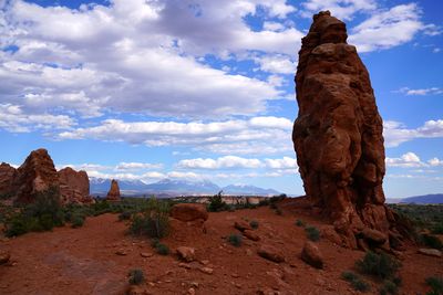 Rock formations on landscape against cloudy sky